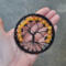halloween style tree of life, created with black wire and nestled in black yarn wrapped metal hoop, decorated with orange crackle beads